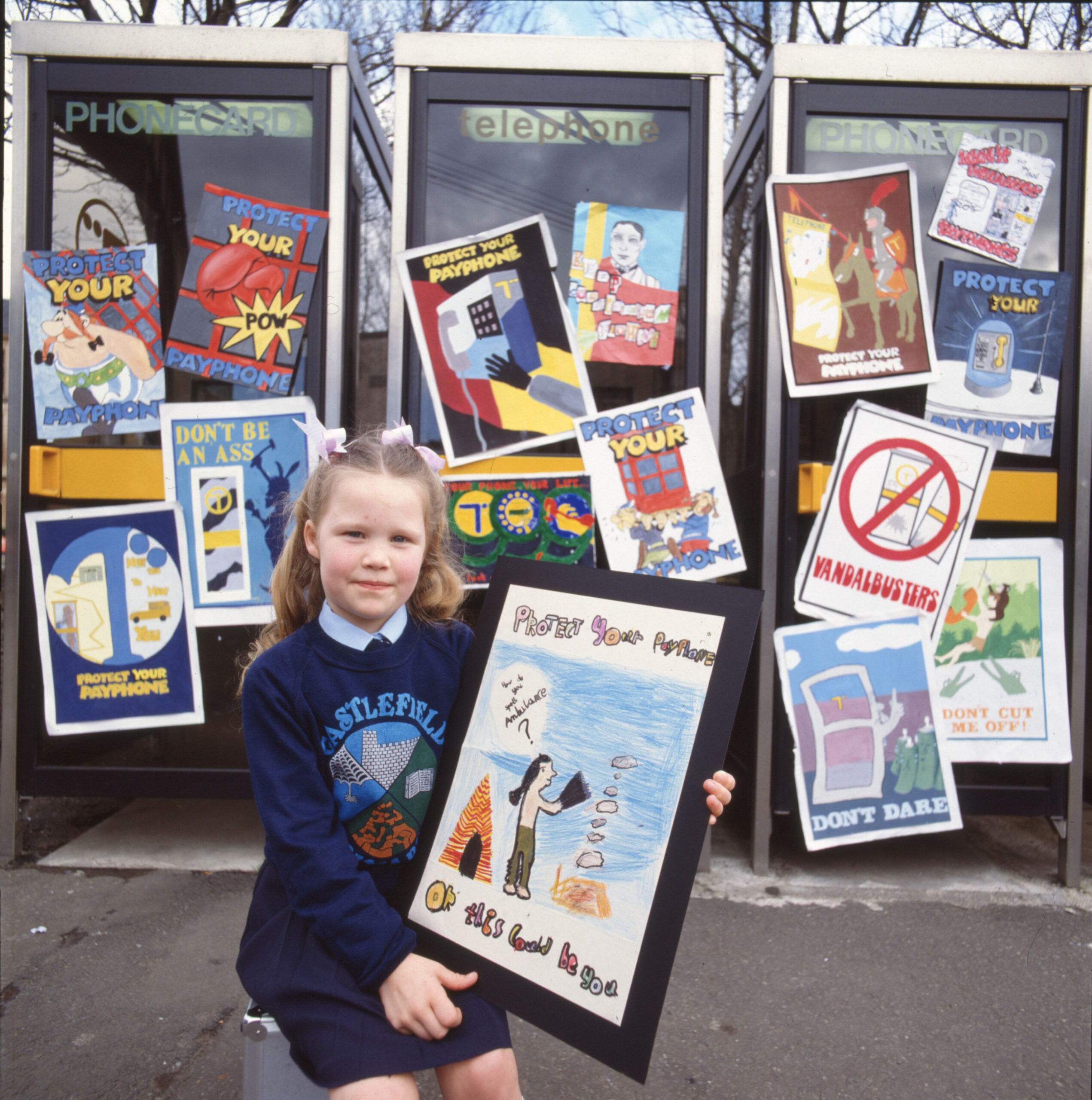 Child holding a painting for the competition ‘Protect your payphone’ (1989)
